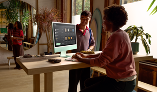 Ein Verkäufer bearbeitet eine Transaktion für seinen Kunden problemlos auf einem 24 Zoll iMac in Grün